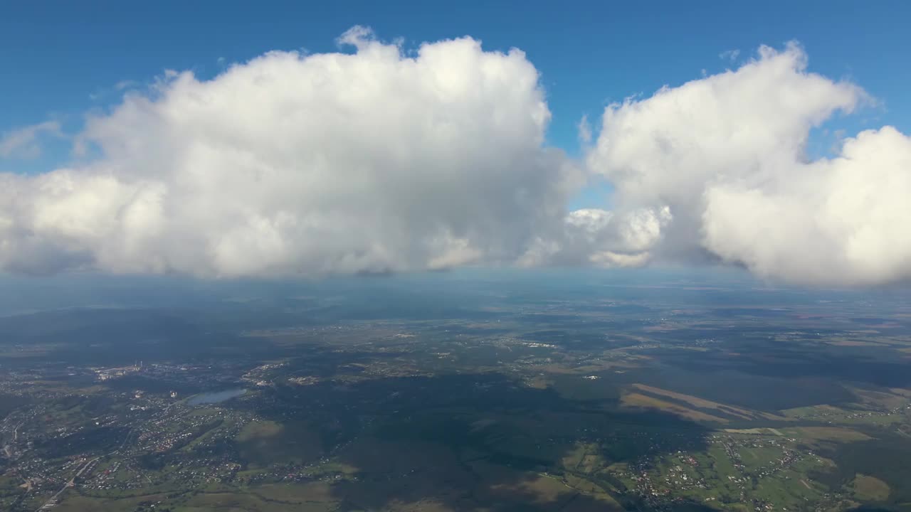 高空鸟瞰图，远处的城市被暴雨前形成的蓬松积云覆盖视频素材