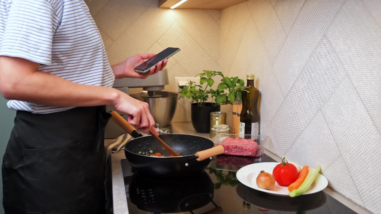 女人在煮肉酱，还用智能手机视频素材