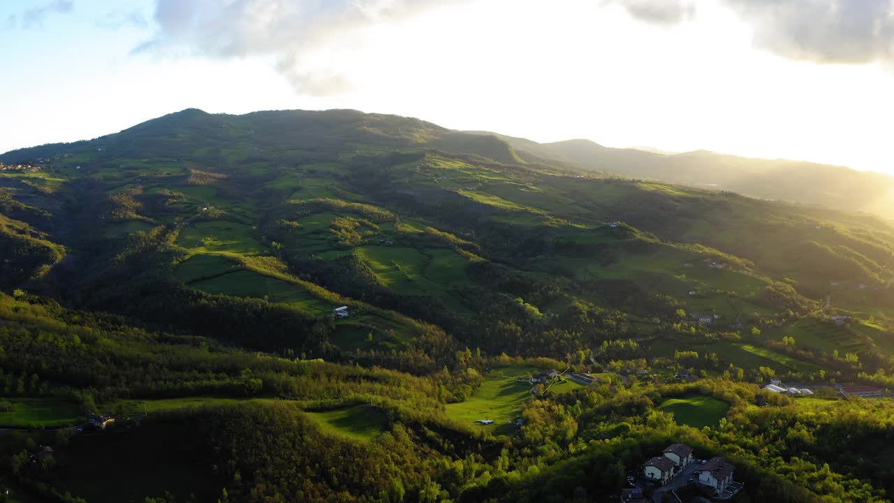 空中向前建造结构在绿色的山丘上反对多云的天空-亚平宁山脉，意大利视频素材