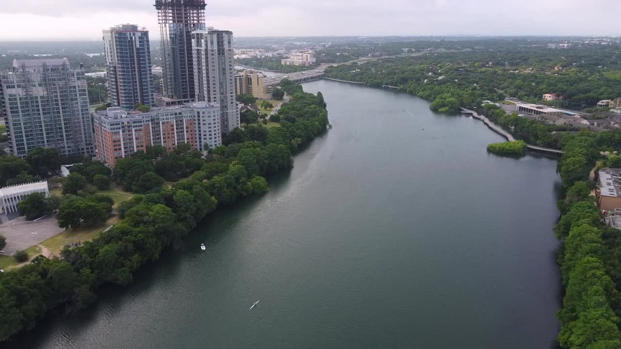 空中拍摄的科罗拉多河在城市建筑，无人机飞行在水面上，奥斯汀，德克萨斯州视频素材