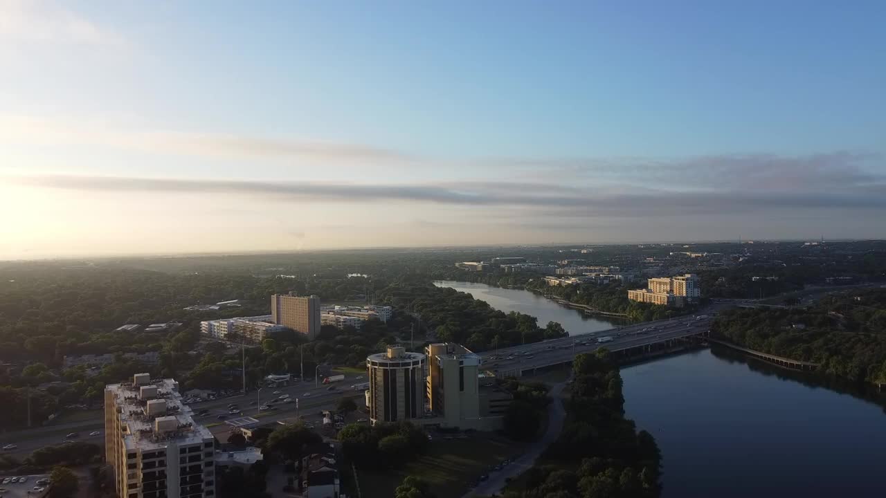 空中拍摄的科罗拉多河上的桥在日落时的天空中，无人机飞向城市中的车辆-奥斯汀，德克萨斯州视频素材