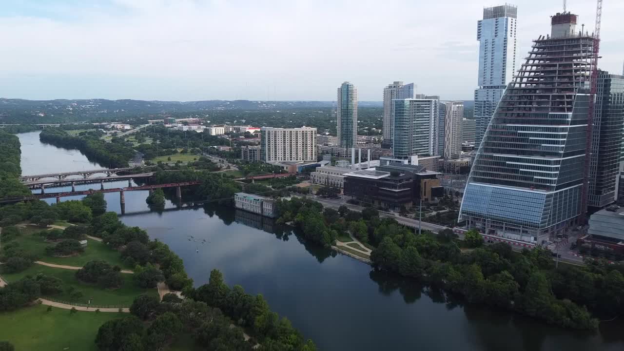 航拍的现代在建建筑在河边，无人机在城市上空向前飞行-奥斯汀，德克萨斯视频素材