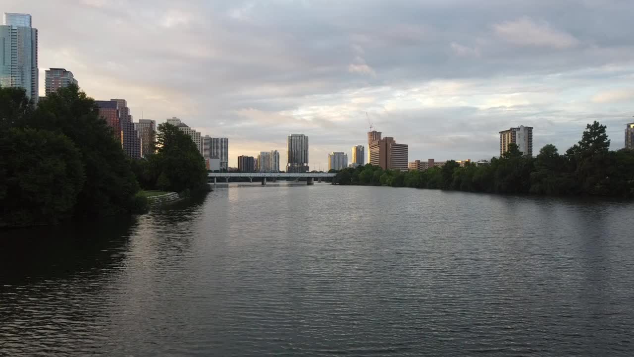 空中:无人机飞越科罗拉多河在城市的建筑中对抗天空-奥斯汀，德克萨斯州视频素材