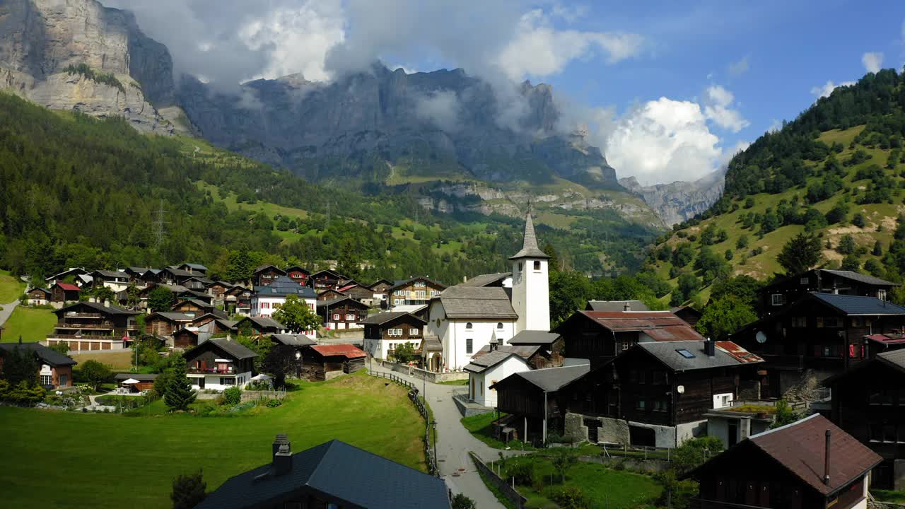 空中向后拍摄的住宅在绿色的山景观-瓦利亚斯，瑞士视频素材