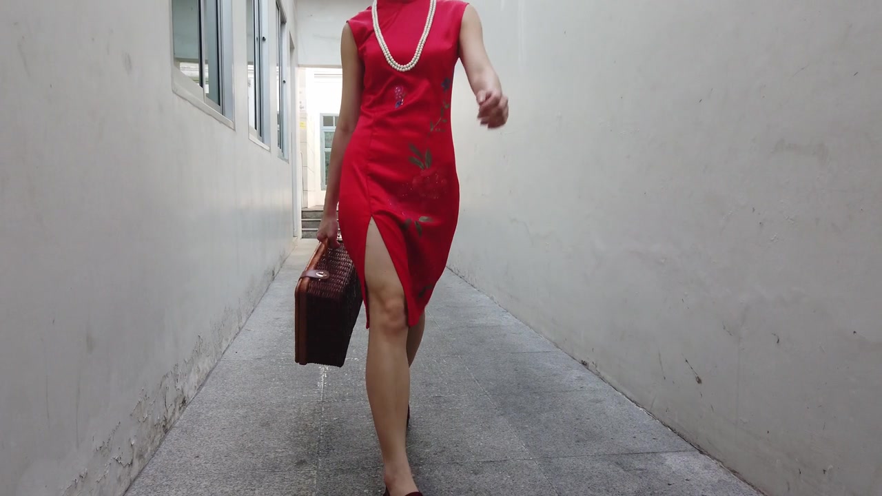 中国年轻女性时装模特在旅行者主题复古中国旗袍走过一个小建筑小巷。视频素材画面3
