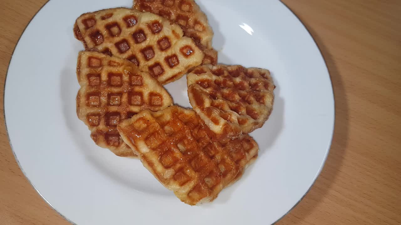 堆叠牛角华夫饼或克罗夫饼服务在白色盘子和木制背景，选择性聚焦图像。视频素材