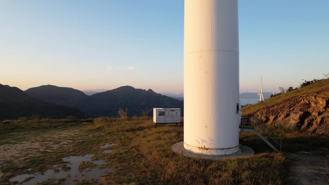 鸟瞰图的风力涡轮机在海边山上的黄昏视频素材