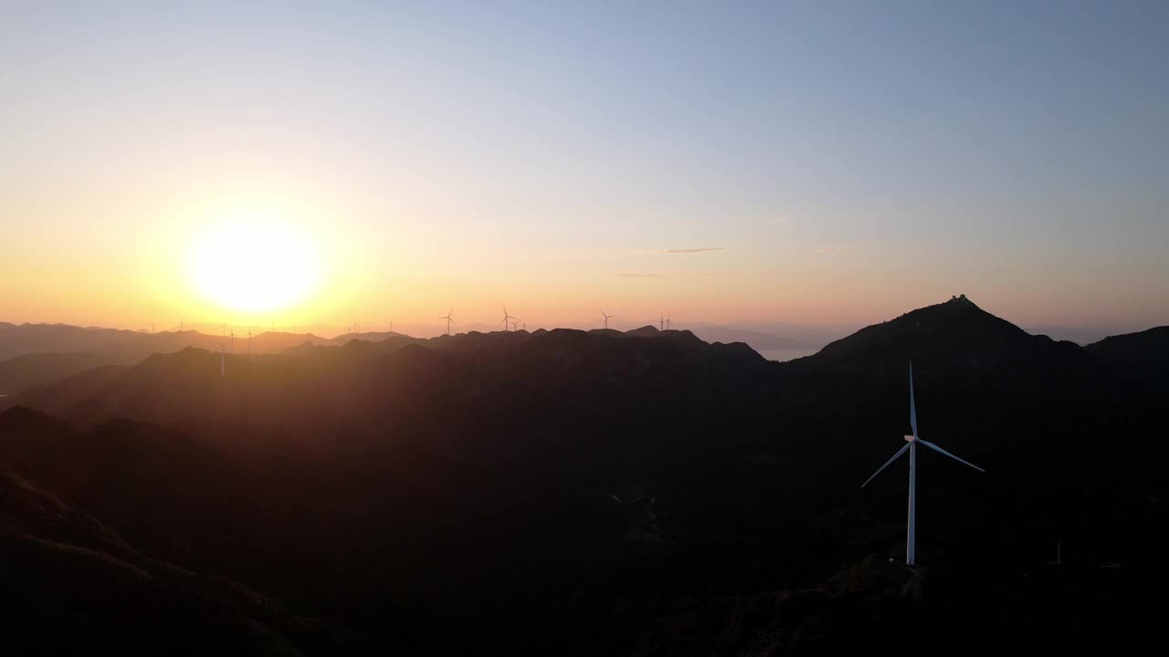 黄昏时，在山顶上排成一行的风力涡轮机视频素材