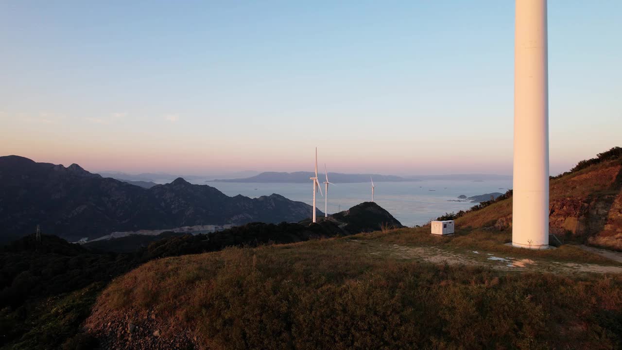 暮色中海边山顶上的风力涡轮机视频素材