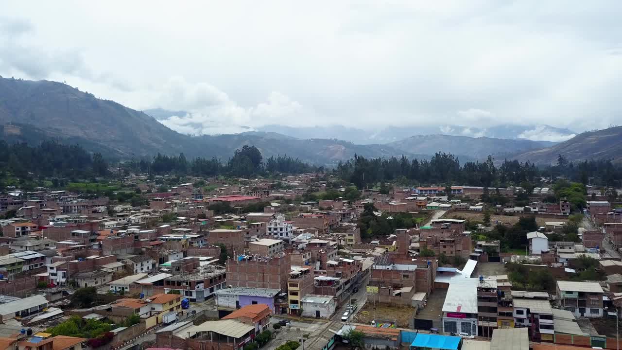 这是从无人机上拍摄的雨从山上和云上越过牧场和房子在Carhuas, Huaras教堂视频素材