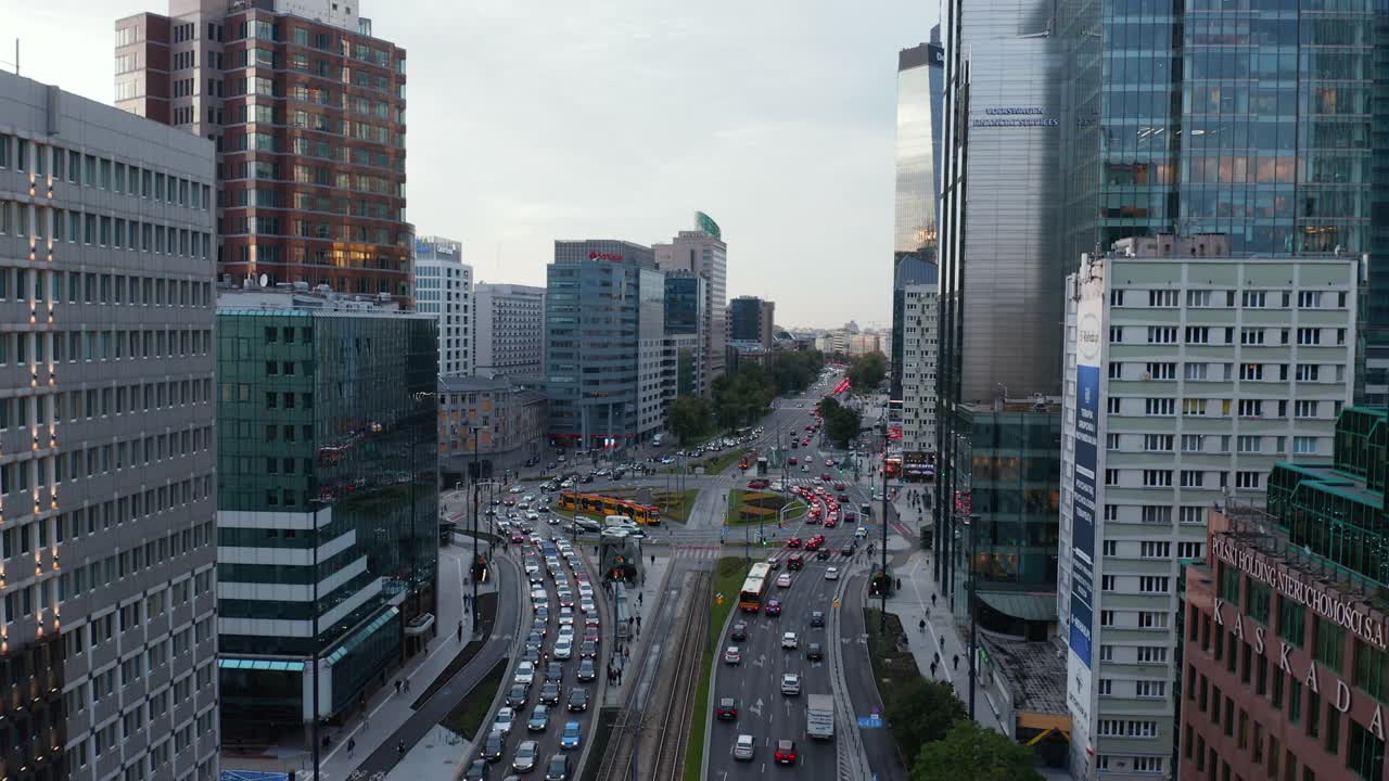 不断上升的繁忙宽阔的街道和十字路口的有轨电车的镜头。高大的办公楼和公寓楼。波兰华沙视频素材