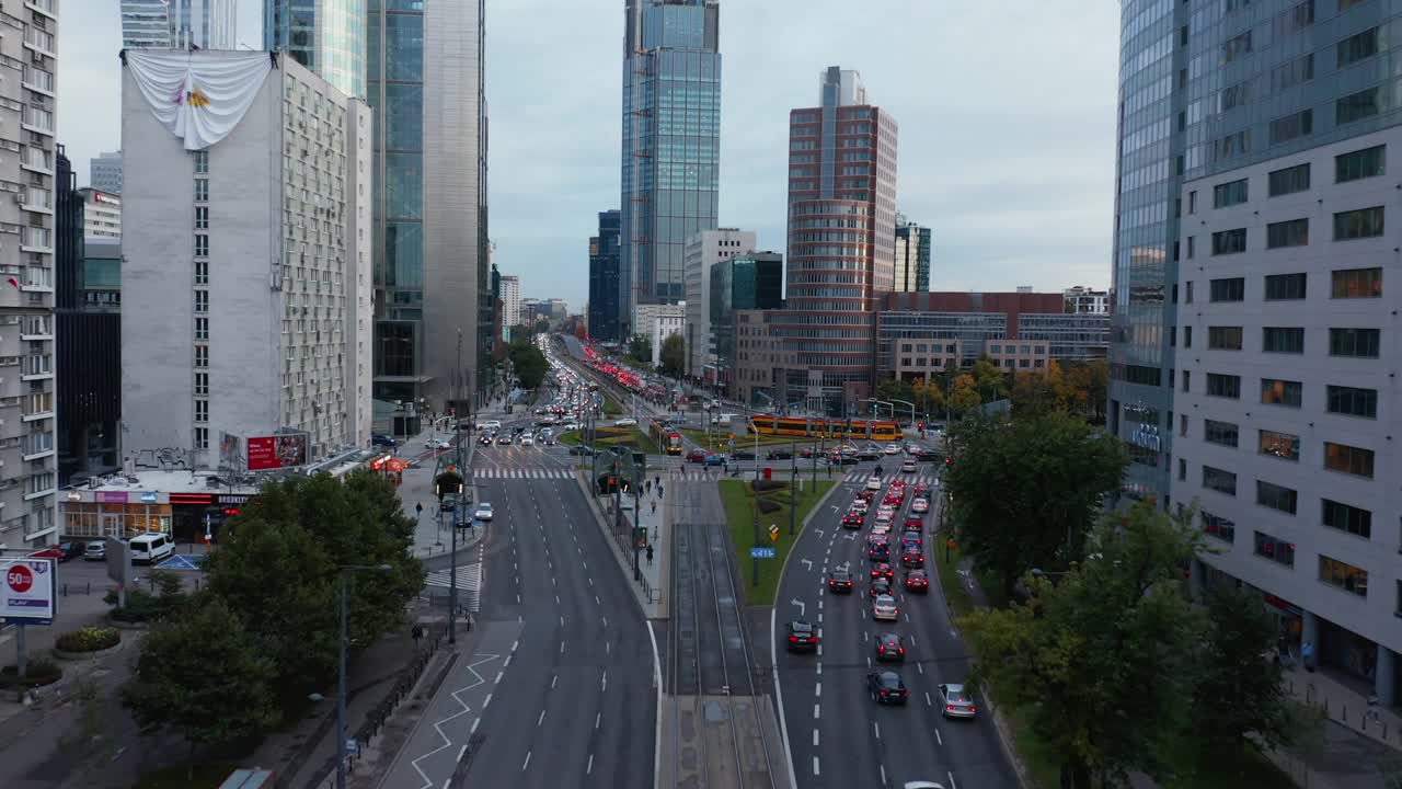 市中心的交通拥挤。向前飞在宽阔的多车道道路和多层建筑之间的大回旋之上。波兰华沙视频素材