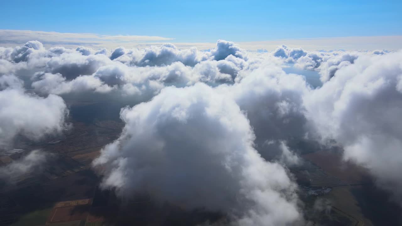 高空从飞机窗口俯瞰被暴雨前形成的蓬松积云覆盖的地面视频素材