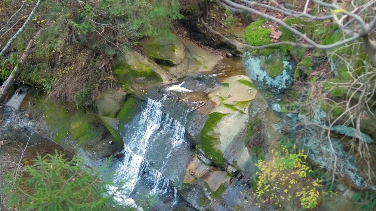 秋天在岩石之间有快速流动的清澈水的小山涧视频素材