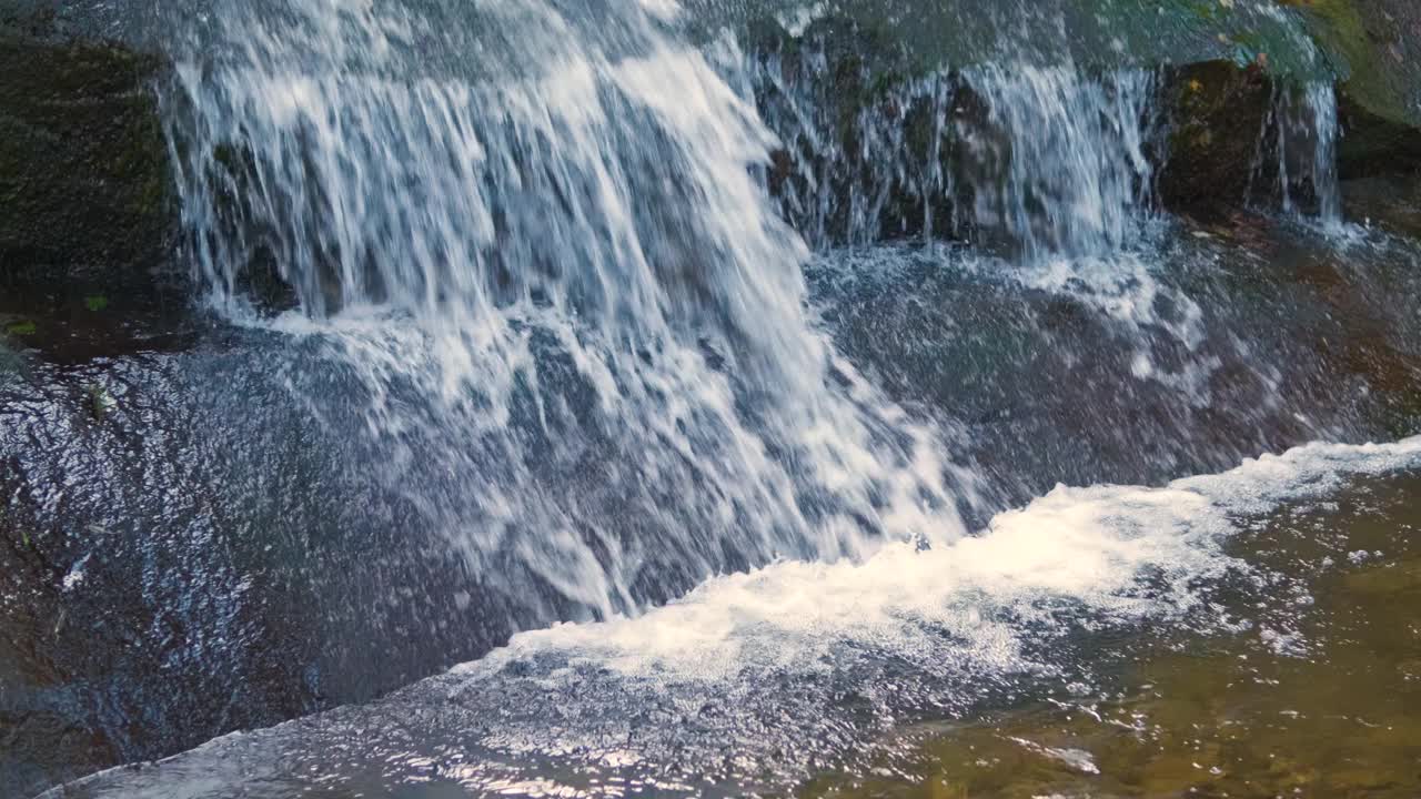 秋天在岩石之间有快速流动的清澈水的小山涧视频素材