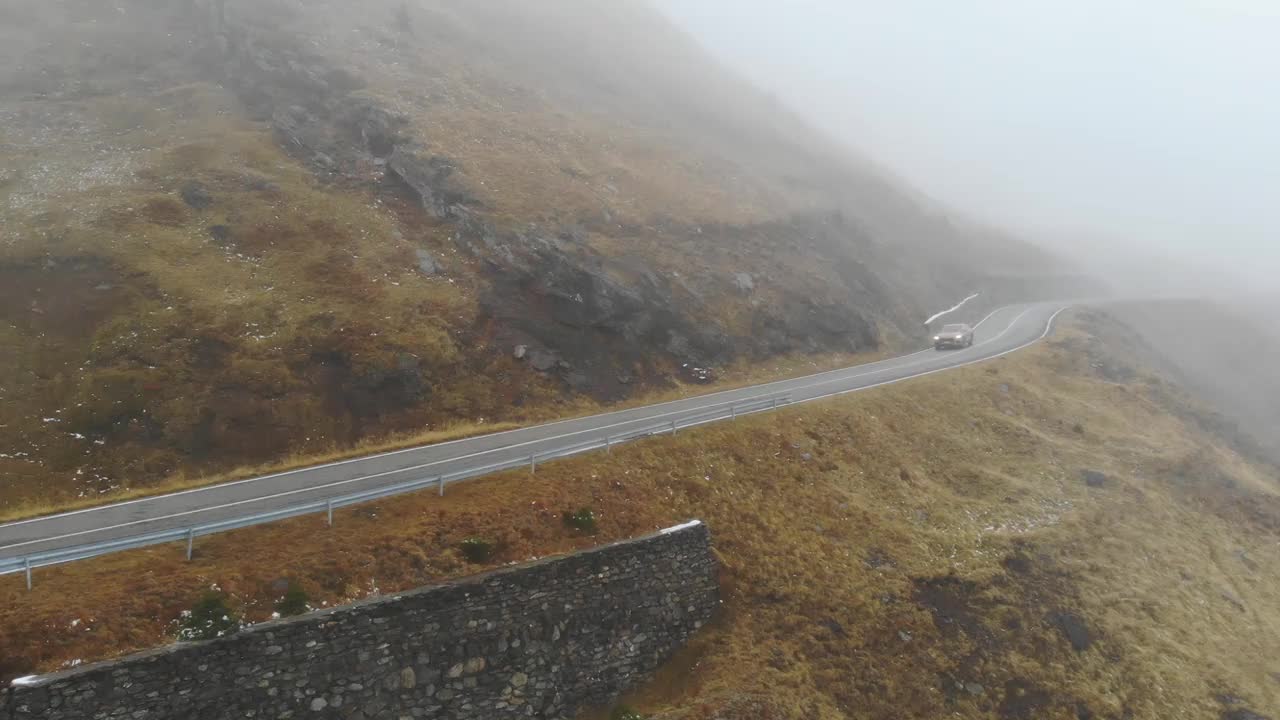 橙色的汽车在秋天的雾山道路上行驶。秋日乡村公路上的汽车航拍。越野车穿过风景秀丽的风景道。旅行的概念。俯视图视频素材