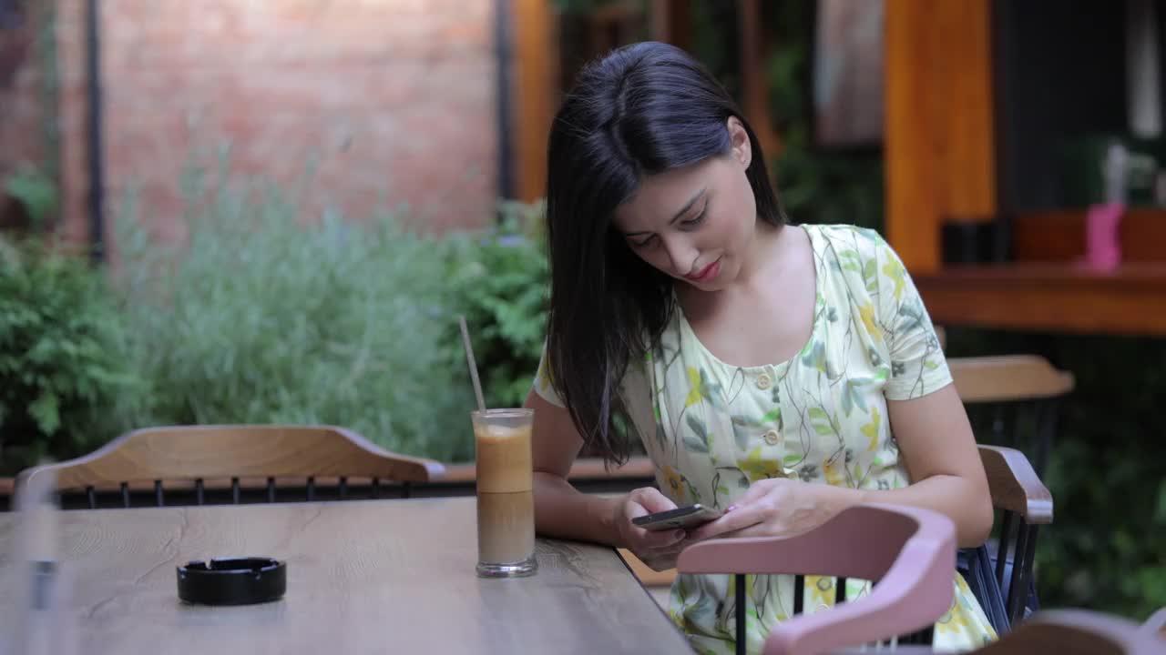 一位年轻的女士正在用手机打café视频素材