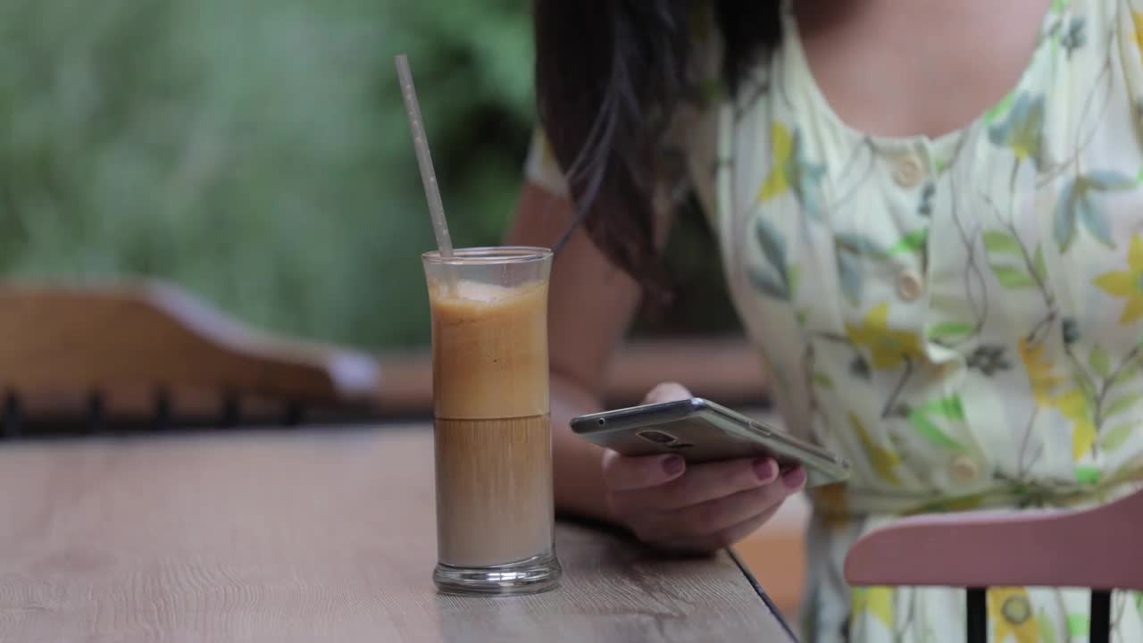 一位年轻的女士正在用手机打café视频素材