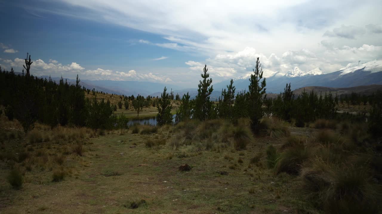 到达秘鲁华拉兹高地的Radian泻湖，这里被几座积雪覆盖的山脉和树木环绕视频素材