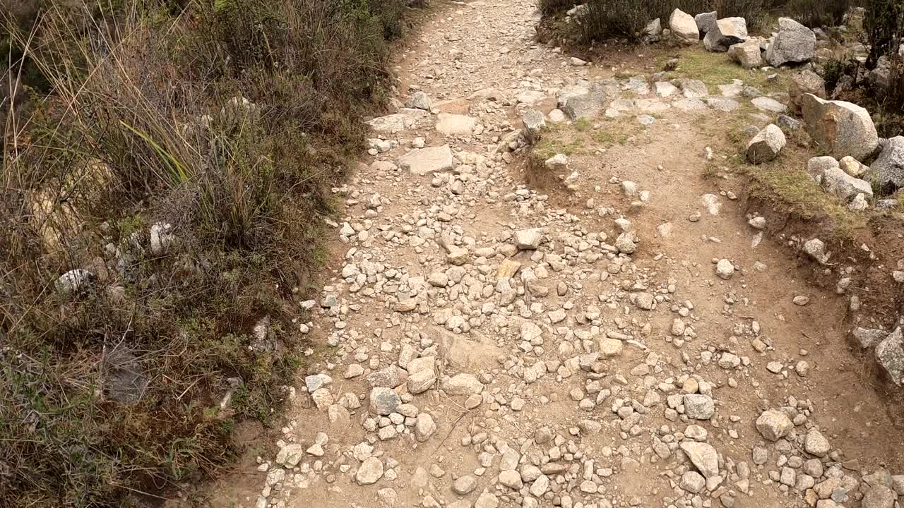 在秘鲁瓦拉兹高地的一座山上徒步行走，沿着陡峭的岩石和泥土小路往下看视频素材