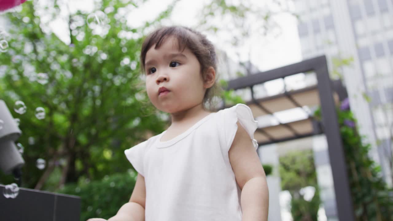 小女孩在公园里玩泡泡视频素材