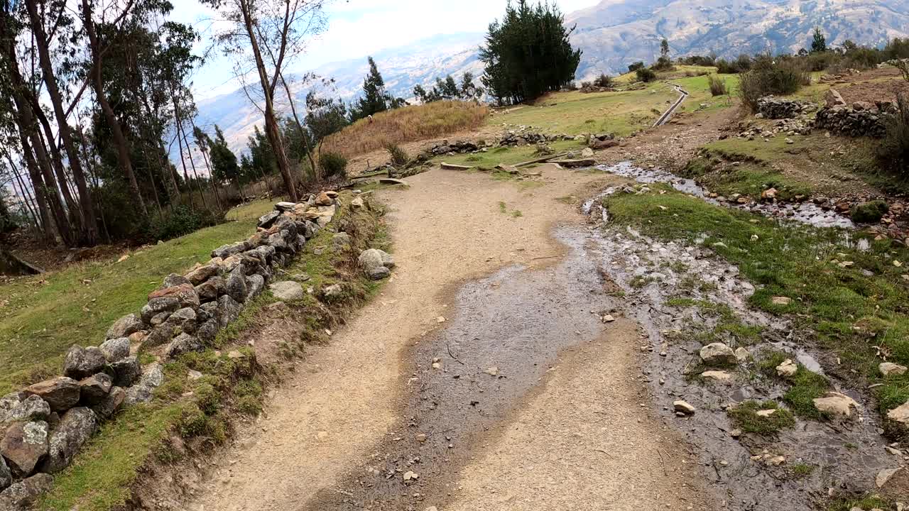 在秘鲁华拉兹高地的一座山上徒步旅行时，用第一人称视角拍摄了从泻湖和积雪覆盖的山上倾泻而下的冰水，穿过裸露的混凝土涵洞流入这座城市视频素材