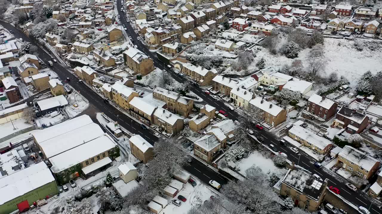 英国西约克郡科克里斯的米尔菲尔德镇冬季下雪天的航拍镜头显示了住宅小区、房屋和屋顶被雪覆盖的房屋视频素材