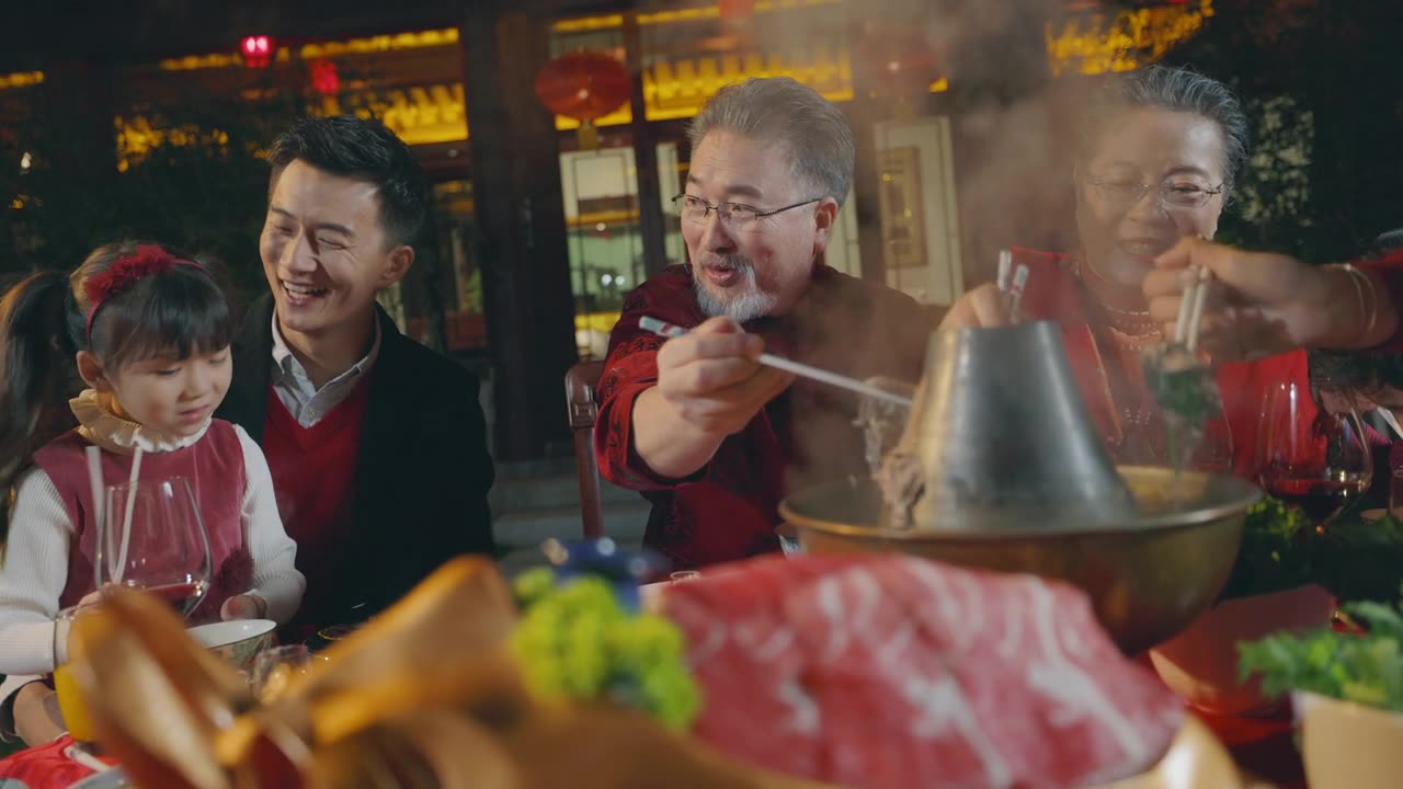 东方家庭在春节期间在中国的院子里吃晚饭视频素材画面1