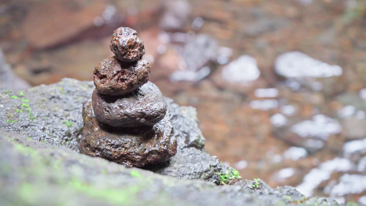 在路过的水边堆放着禅石。靠近河流的岩石保持平衡。视频下载