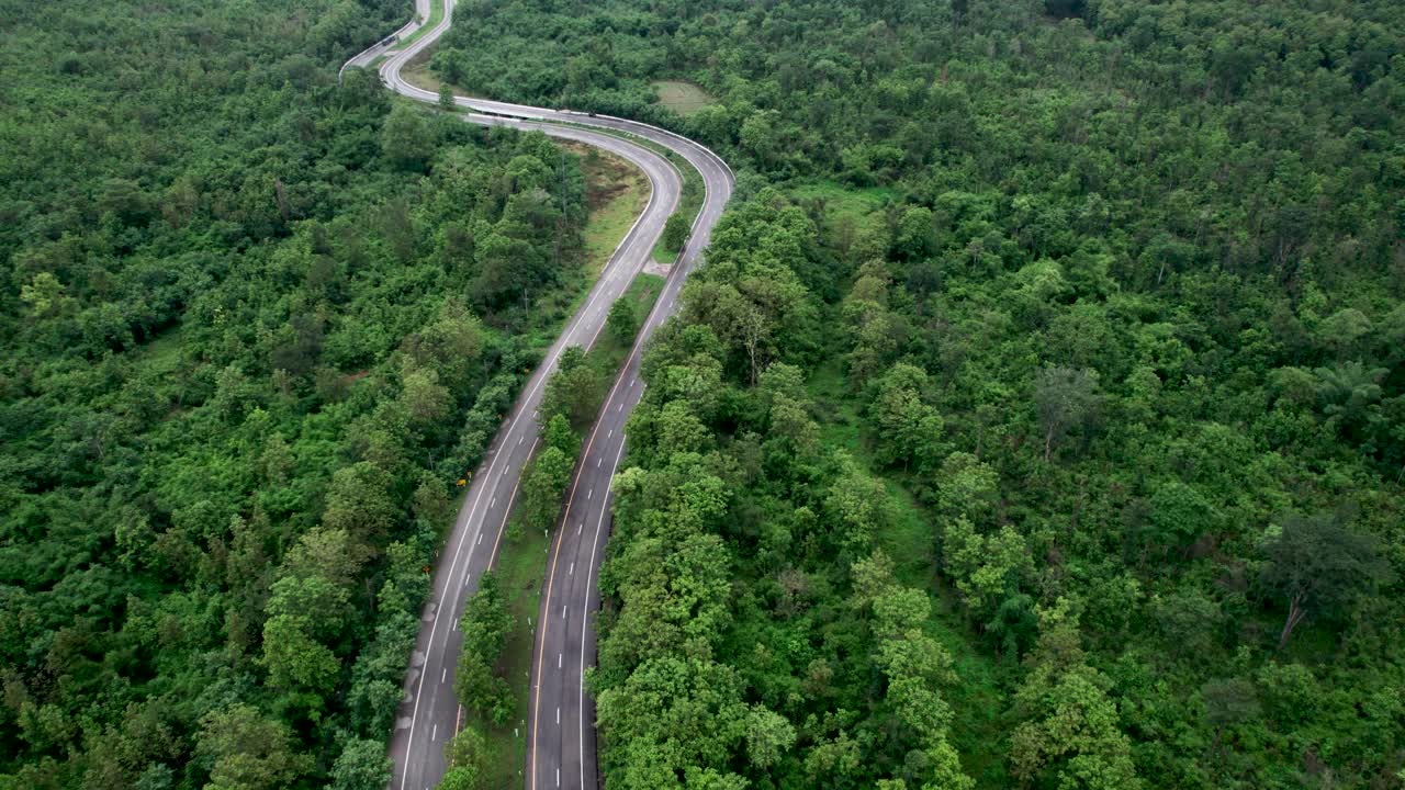 俯瞰通过绿色森林和山的乡村道路视频素材