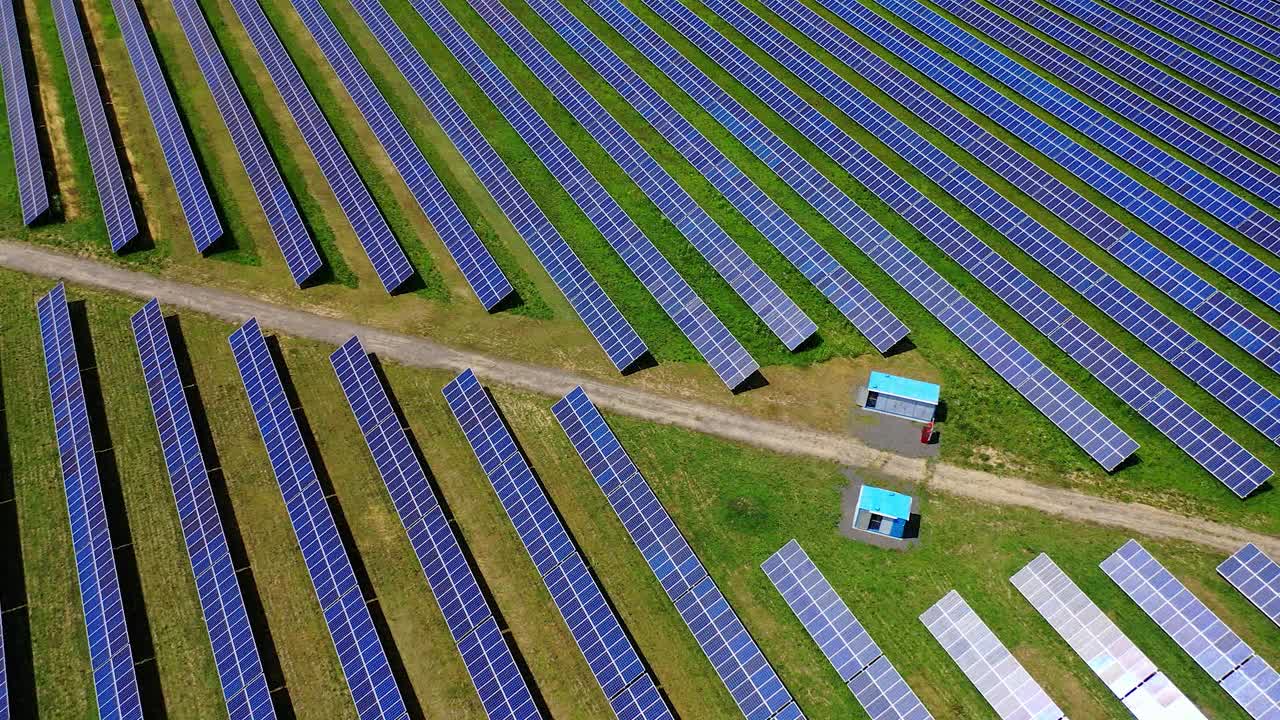 巨大的太阳能发电厂。太阳能农场的蓝色光伏电池板。现代工业用于生产来自太阳的生态能源。鸟瞰图。视频素材