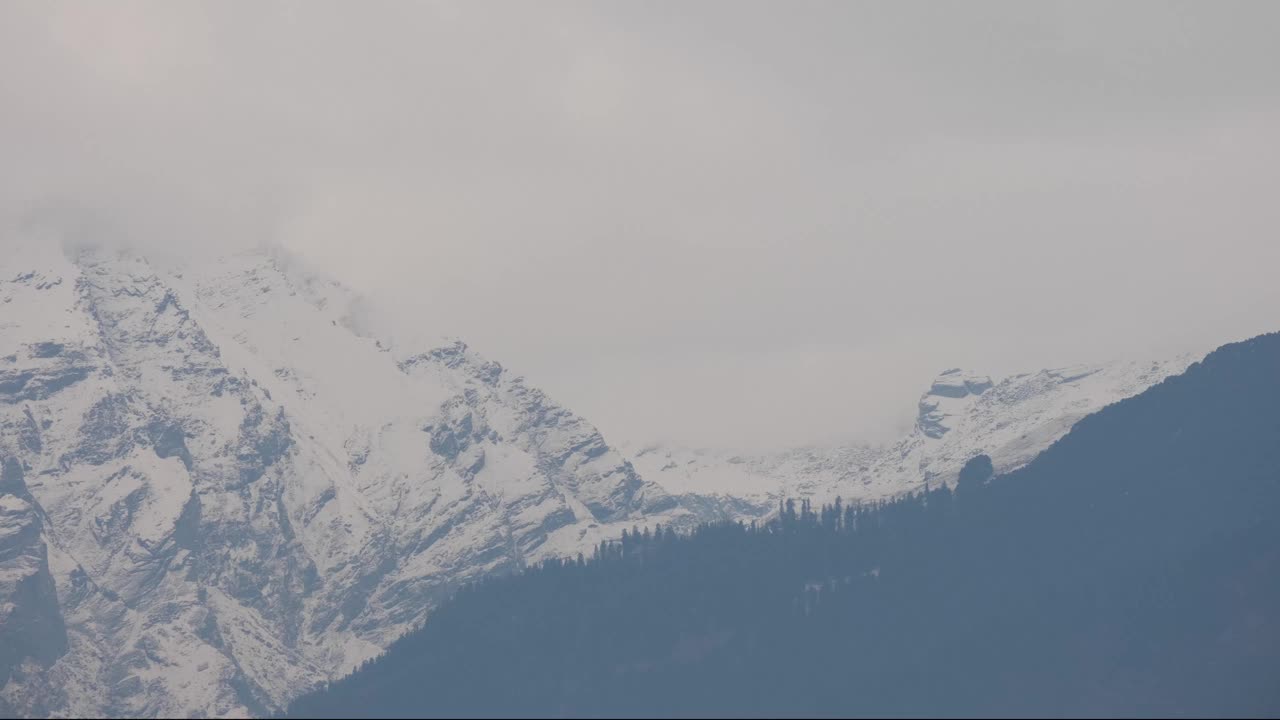 这是一段积雪覆盖山峰被雾和云覆盖的延时视频视频素材