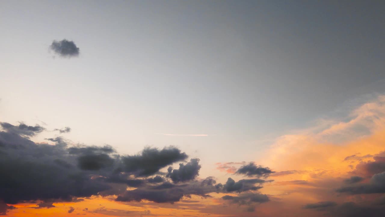 黑暗的夜空，阳光下的灰橙色云的全景。视频素材