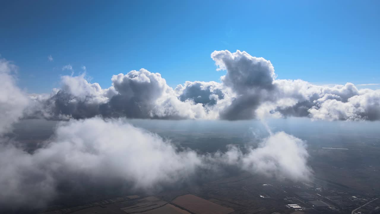 高空从飞机窗口俯瞰被暴雨前形成的蓬松积云覆盖的地面视频素材