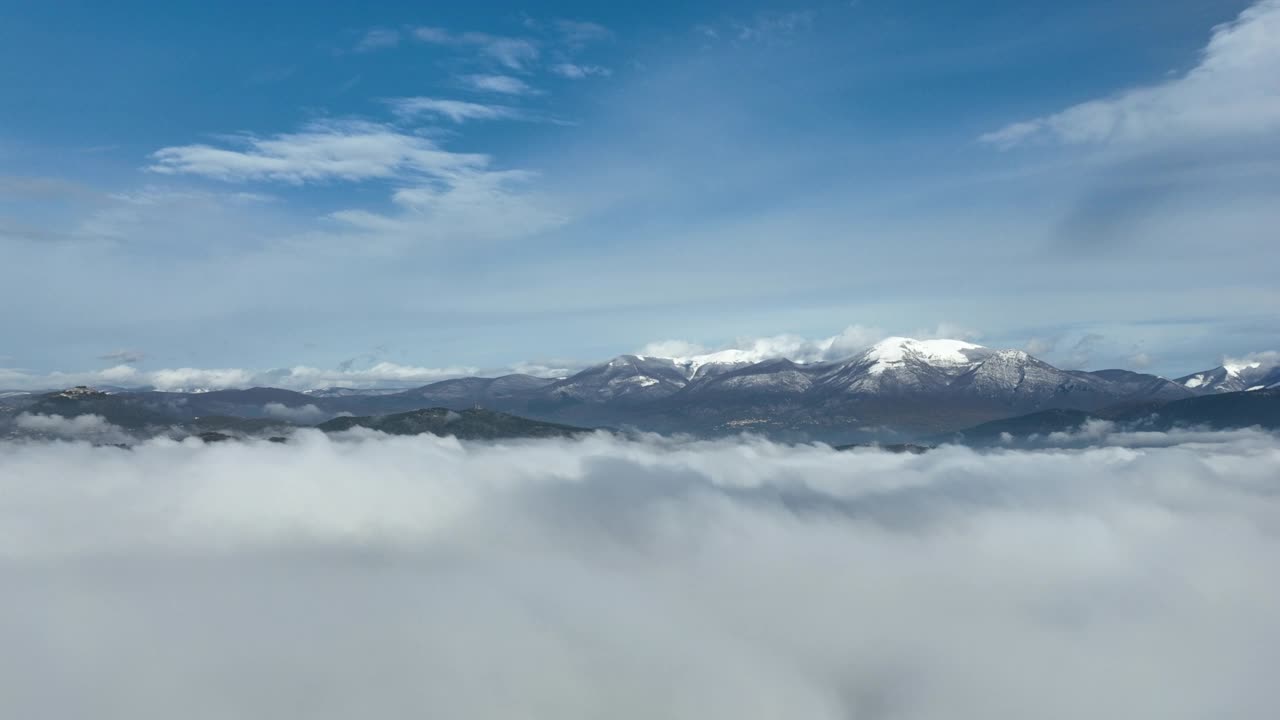 在云层之上飞行，令人惊叹的鸟瞰图，在意大利的一个冬天，积雪覆盖的山脉被云层包围。视频素材