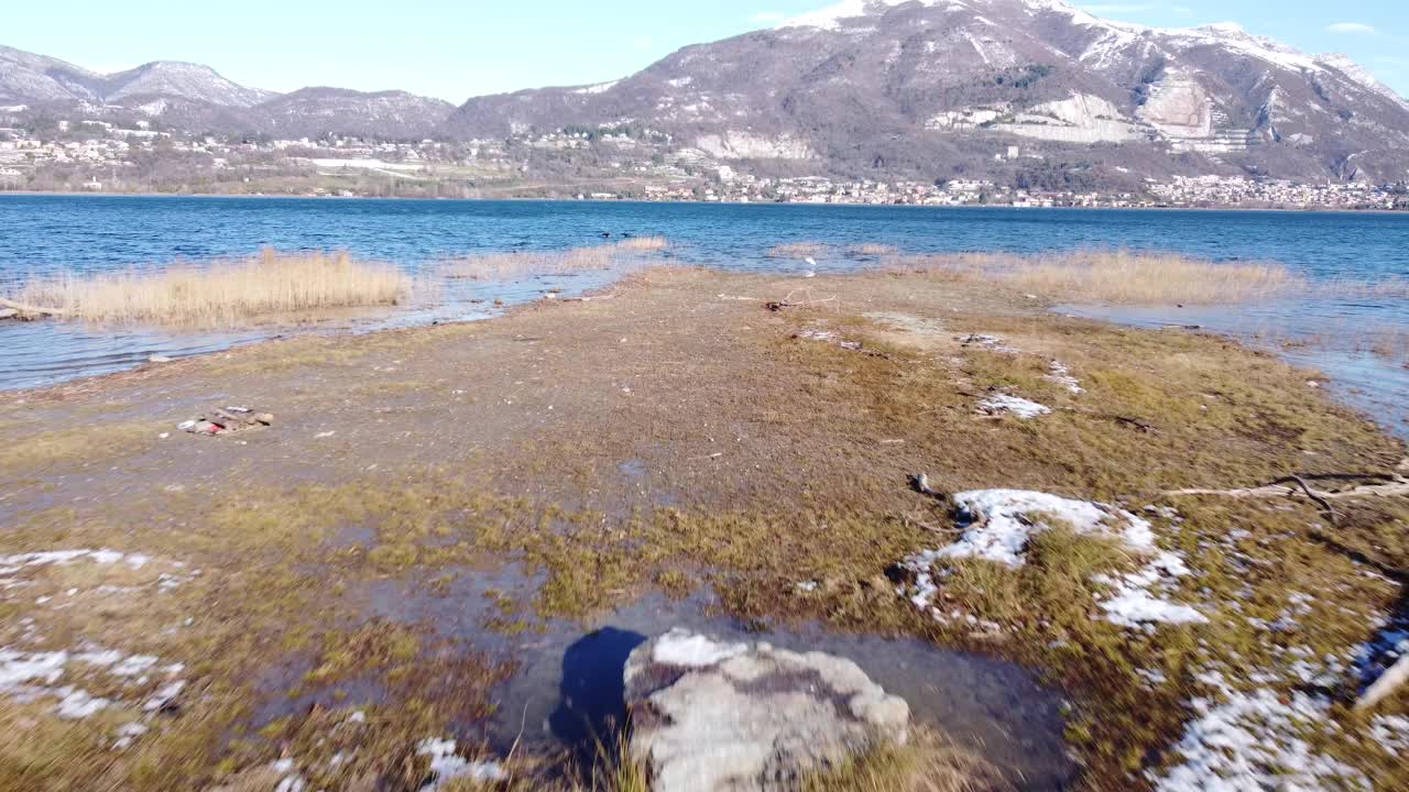 无人机升起在雪后的高山湖水之上。前视图。苍鹭。米兰,意大利伦巴第视频素材