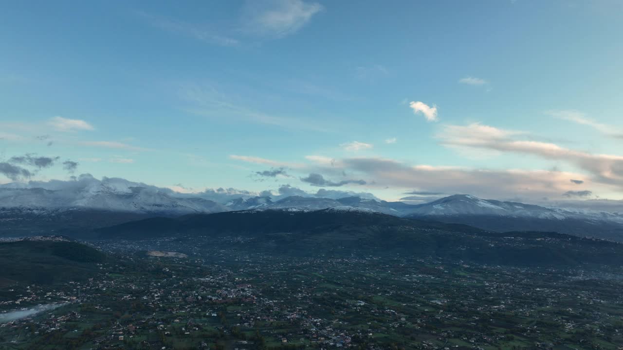 从空中俯瞰，一个美丽的山谷和远处的山脉在阴天。视频素材