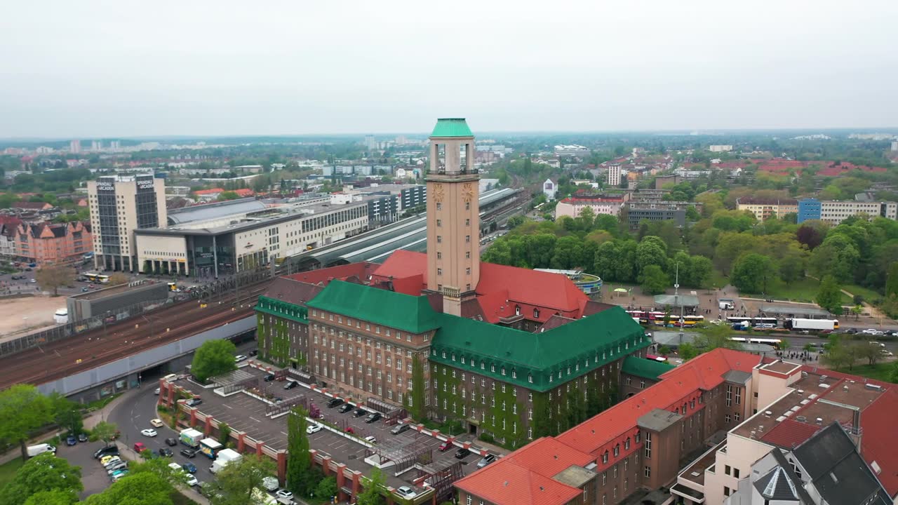 在Rathaus Spandau的高塔上飞行。斯潘道镇市政厅的历史建筑。以火车站为背景的城市。柏林,德国视频素材画面1