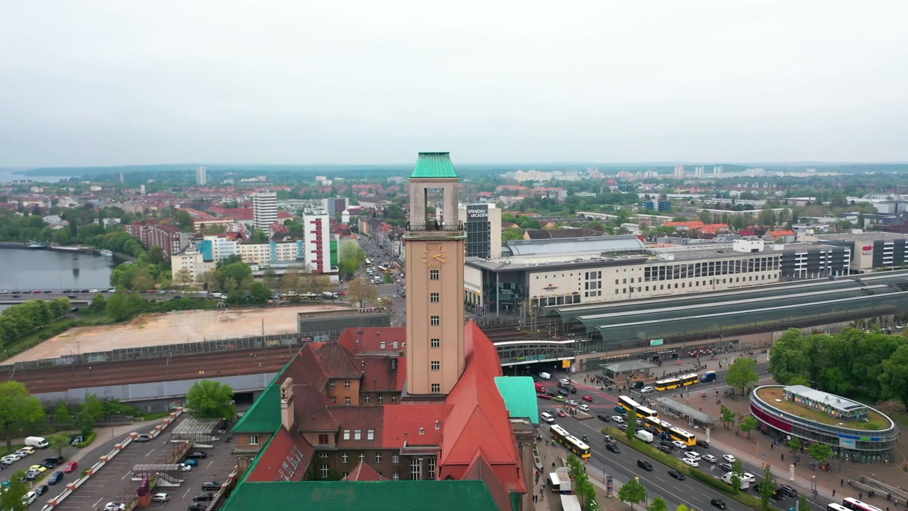 在Rathaus Spandau的高塔上飞行。斯潘道镇市政厅的历史建筑。以火车站为背景的城市。柏林,德国视频素材画面4