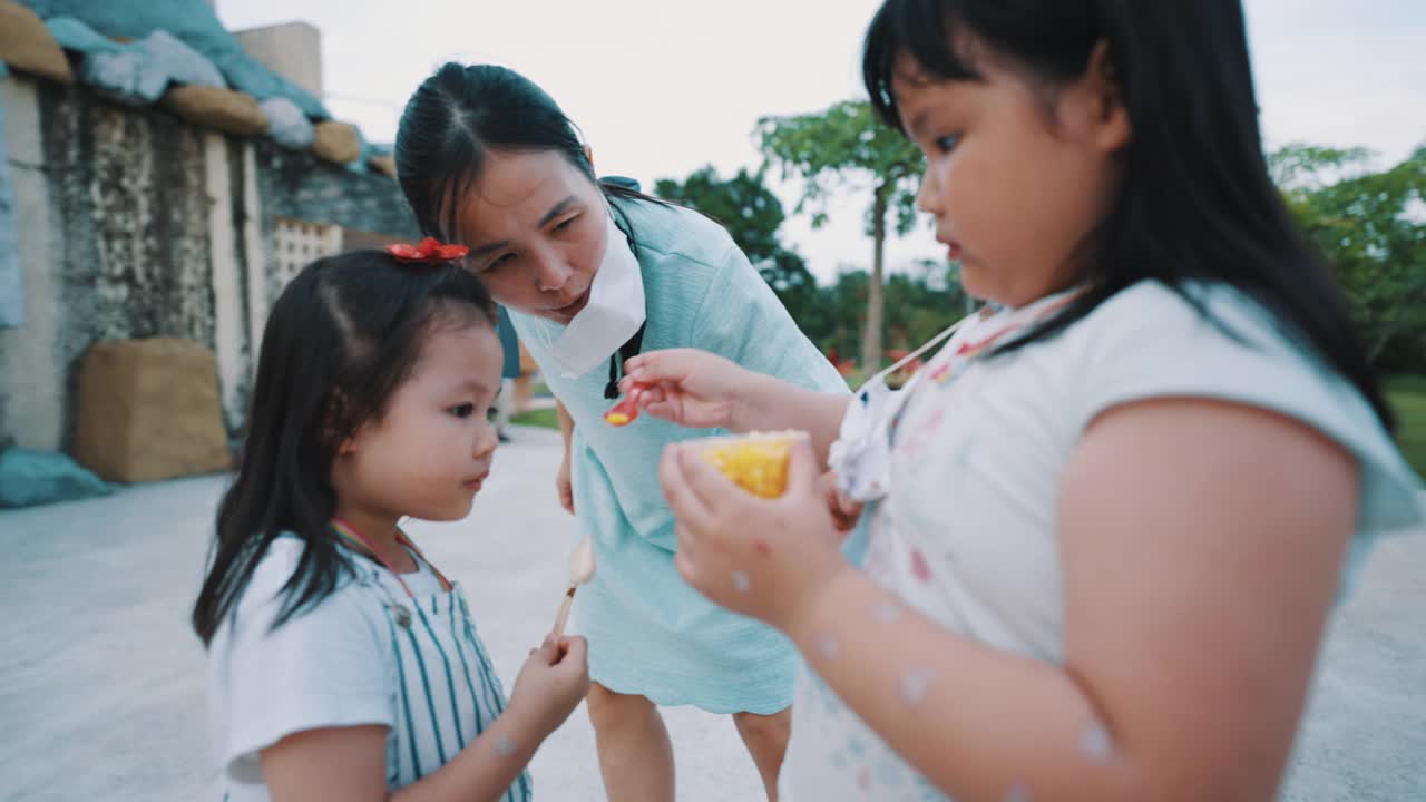 亚洲姐妹和姐妹快乐吃冰淇淋。视频素材