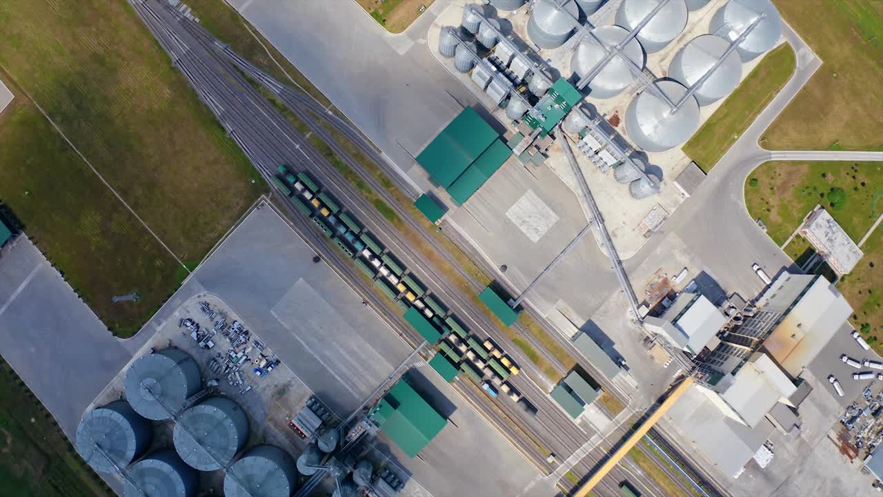 粮食筒仓。铝容器储存收获。在工业区内有货运列车的铁路。田间银纹终端。前视图。农业的概念视频素材