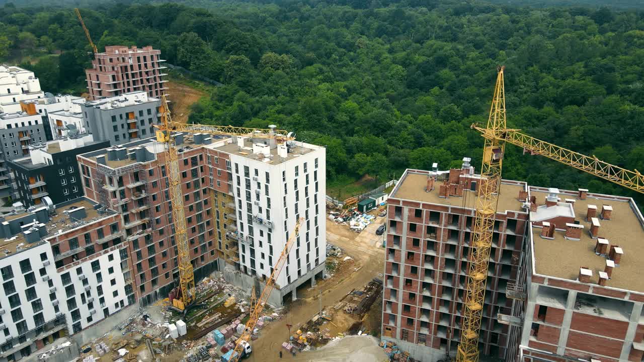 城市建设工地，鸟瞰图。高架起重机在建筑工地作业。起重机及建筑施工现场视频素材