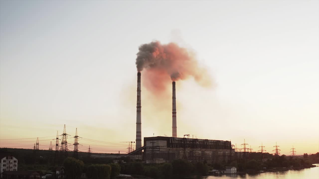 静态视图的高压塔天空背景，工厂管道与烟雾超过它。地球污染与工业化理念。有选择性的重点视频素材