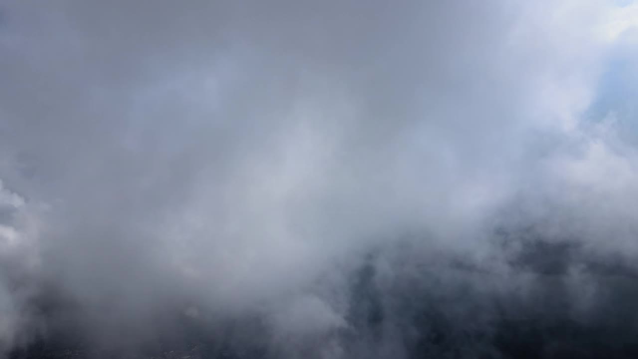 从飞机窗口高空俯瞰，在暴雨前形成的蓬松的积云覆盖着大地视频素材