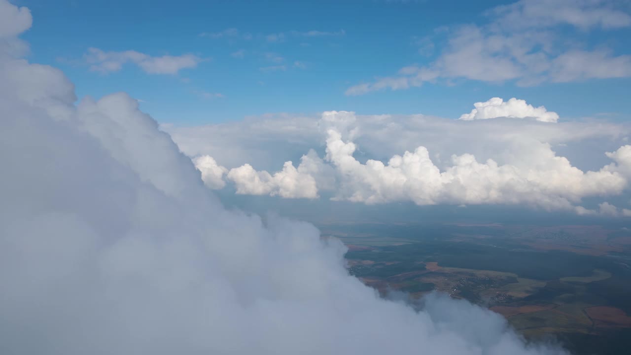 从飞机窗口高空俯瞰，在暴雨前形成的蓬松的积云覆盖着大地。视频素材