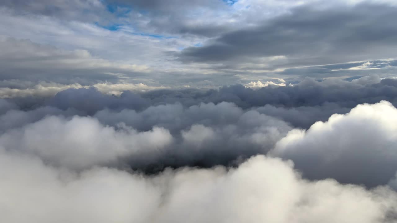 从飞机窗口高空俯瞰，在暴雨前形成的蓬松的积云覆盖着大地。视频素材