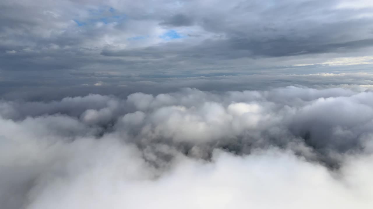 从飞机窗口高空俯瞰，在暴雨前形成的蓬松的积云覆盖着大地视频素材