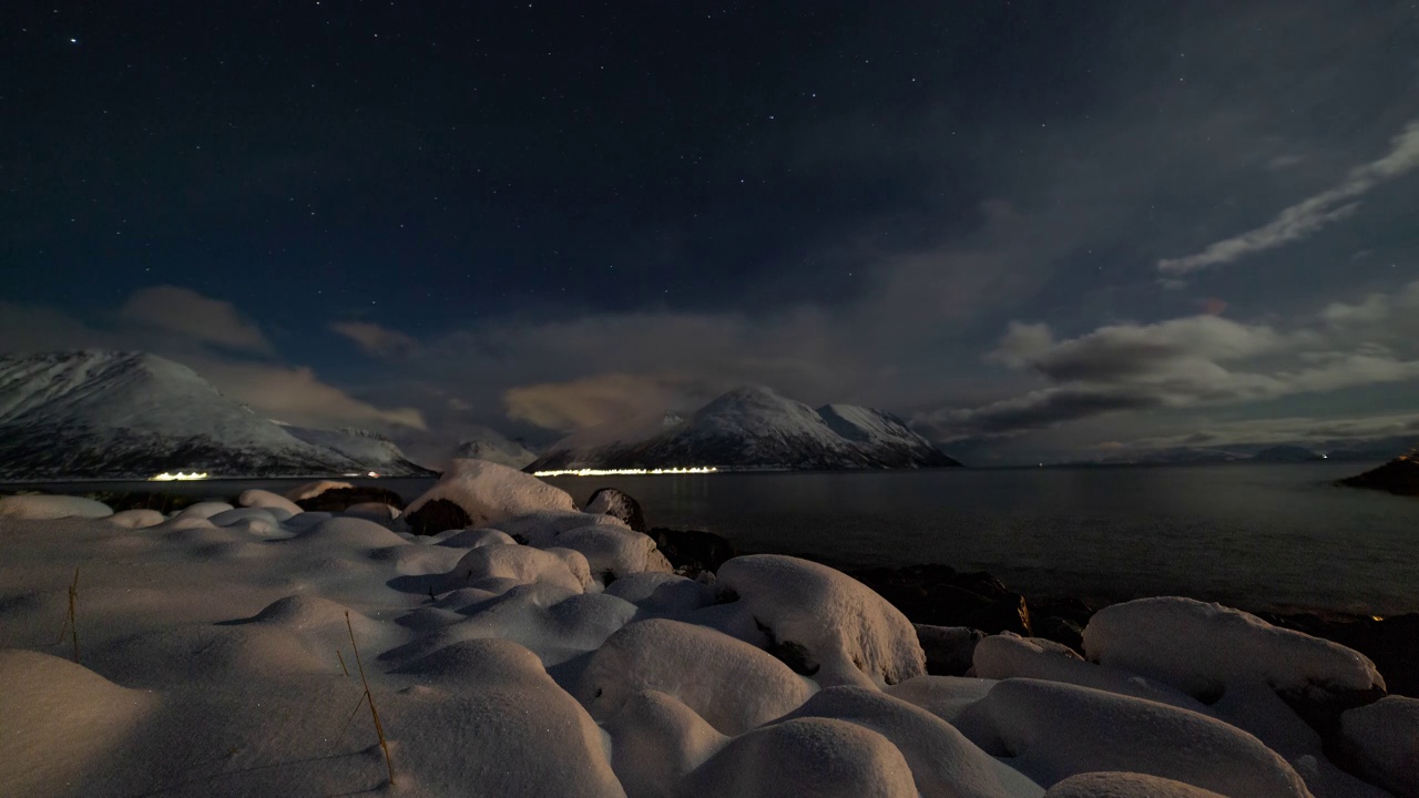 挪威北部雪顶峡湾海滩上的夜云随着时间流逝视频素材