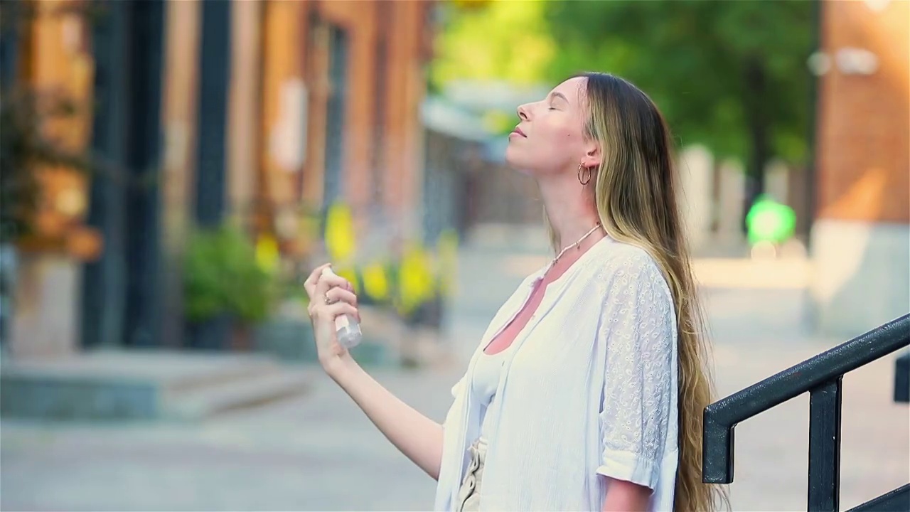 年轻漂亮的女人在炎热的天气里让她的脸焕然一新视频下载