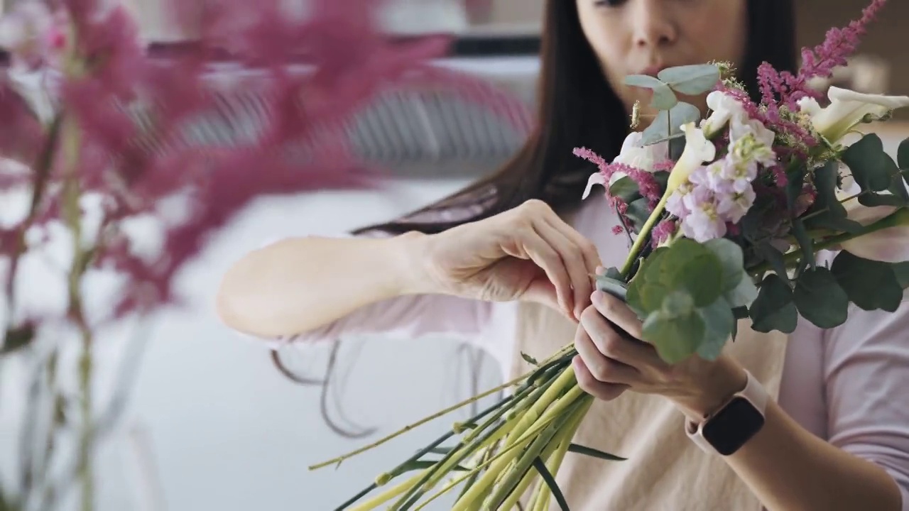 关闭亚洲女性花店，店主小生意花店，绑花花束。日常事务经营小企业的日常事务视频素材画面1
